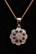A DIAMOND AND RUBY PENDANT NECKLACE, the yellow metal pendant of a flower form, set with a central