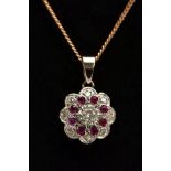 A DIAMOND AND RUBY PENDANT NECKLACE, the yellow metal pendant of a flower form, set with a central