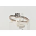 A WHITE METAL DIAMOND RING, designed with a square mount set with four princess cut diamonds, within