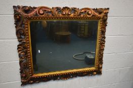 A 19TH CENTURY GILTWOOD WALL MIRROR, with open foliate scrolls, frame 97cm x 82cm, mirror 70cm x