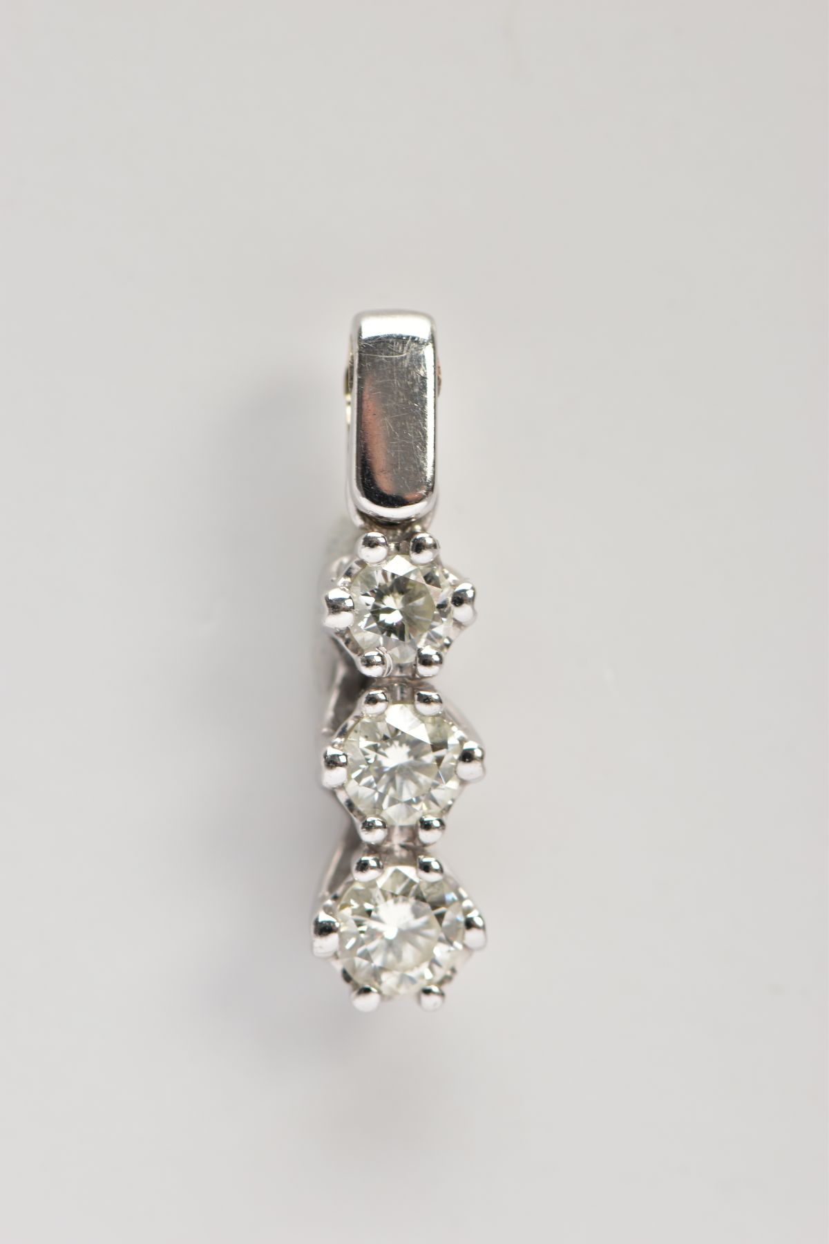 AN 18CT WHITE GOLD, DIAMOND PENDANT, designed with a row of three graduated, claw set, round - Image 2 of 2