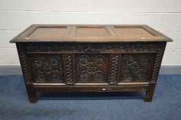 AN 18TH CENTURY CARVED OAK COFFER, the frieze with interlinked lunettes, above three panels with