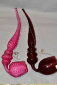 TWO 19TH CENTURY COLOURED GLASS OVERSIZED PIPES, one in ruby glass, the other in opaque pink with