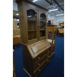 A PINE BUREAU/BOOKCASE, with a fitted interior and three exterior drawers, width 98cm x depth 50cm x