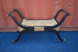 A 20TH CENTURY FRENCH EBONISED AND GILT SAVONAROLA STOOL, with a bergère seat, length 118cm x