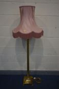 A BRASS BARLEY TWIST STANDARD LAMP on a stepped base, with claw feet, with a pink fabric shade,