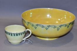 RUSKIN POTTERY, a footed eggshell bowl, covered in a yellow glaze with a band of clover to the outer