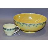 RUSKIN POTTERY, a footed eggshell bowl, covered in a yellow glaze with a band of clover to the outer