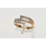 A 9CT GOLD DIAMOND DRESS RING, of a crossover design set with two rows of tapered cut diamonds,