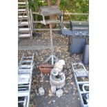 A COMPOSITE GARDEN WATER FEATURE in the form of a lady pouring into a wooden barrel on three