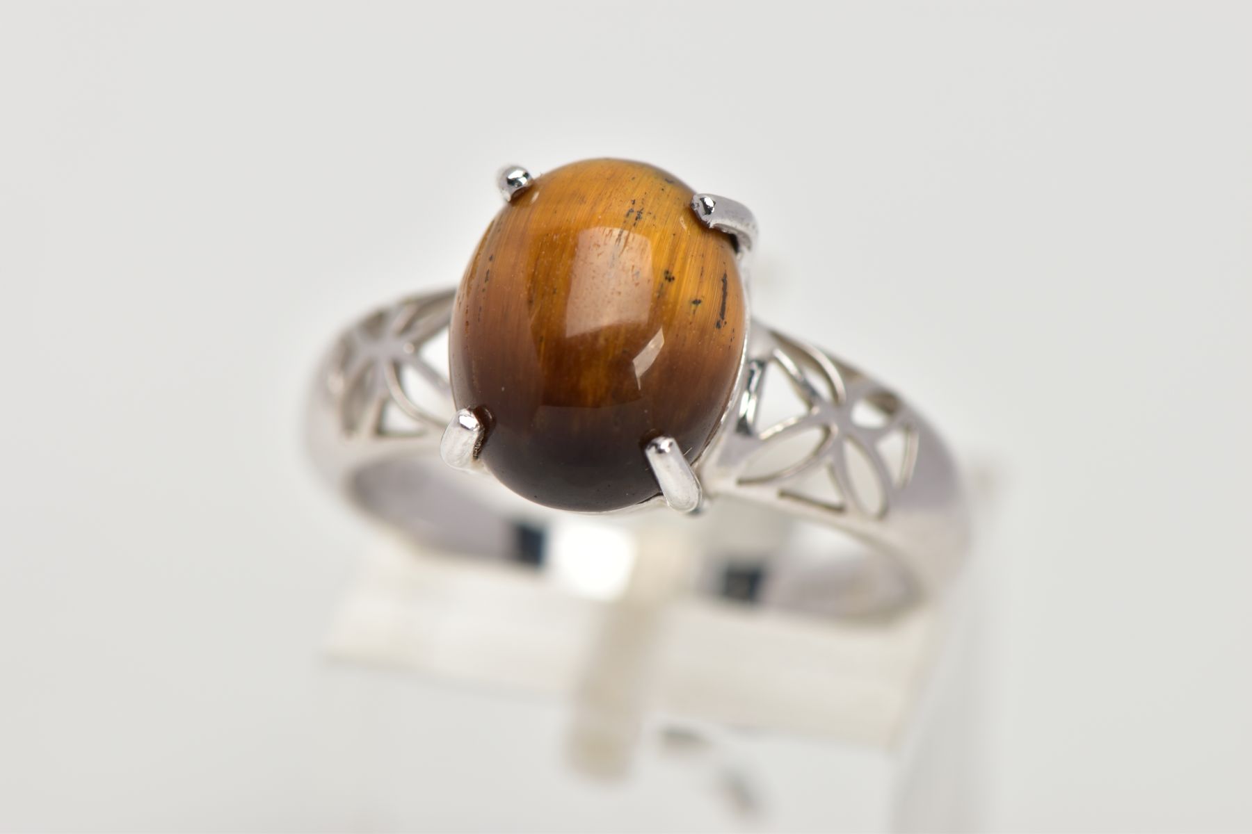 A 9CT WHITE GOLD, TIGER EYE SET RING, designed with an oval tiger eye cabochon, measuring
