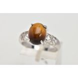 A 9CT WHITE GOLD, TIGER EYE SET RING, designed with an oval tiger eye cabochon, measuring