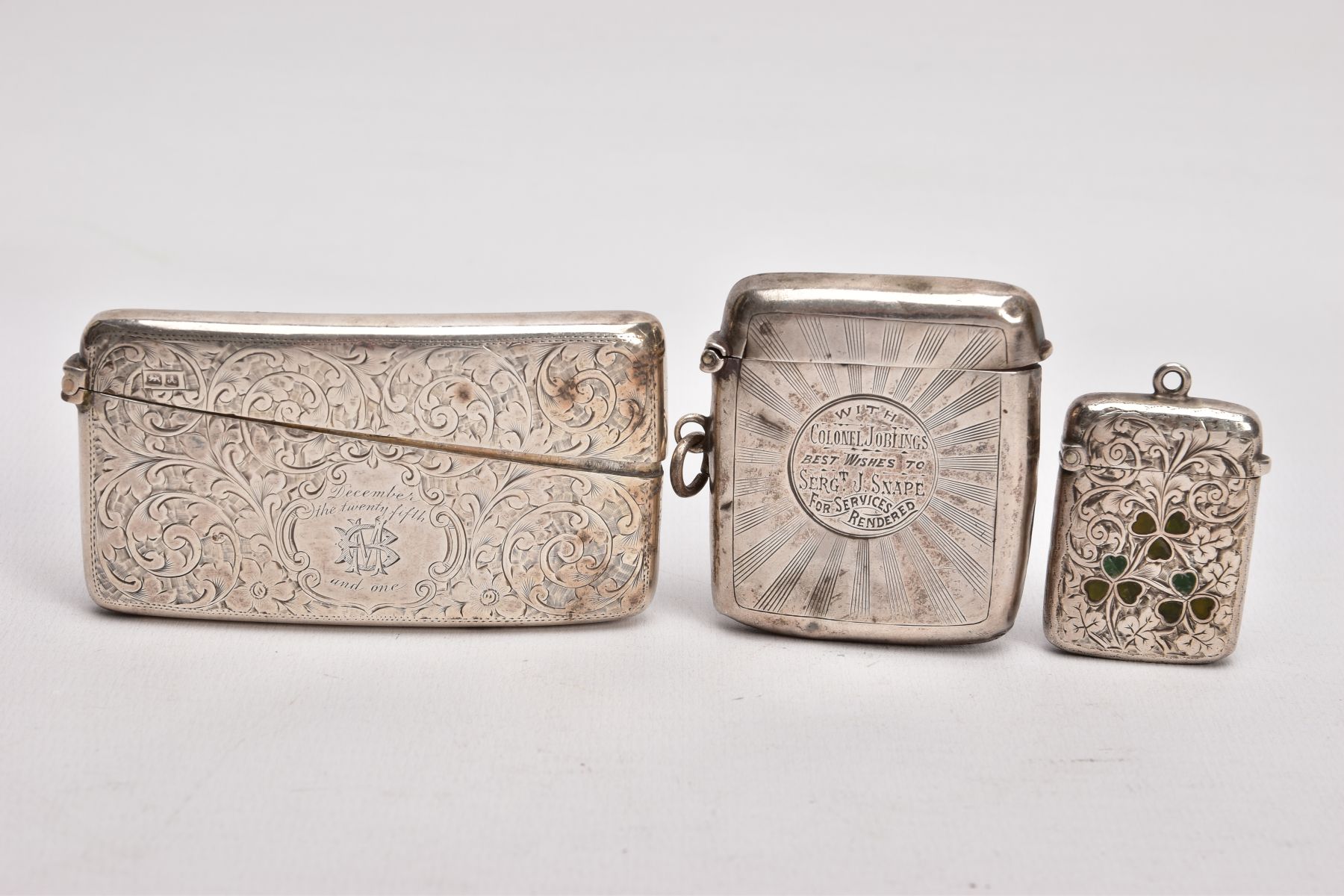 A SILVER CARD CASE AND TWO VESTAS, the card case decorated with an engraved foliate design and