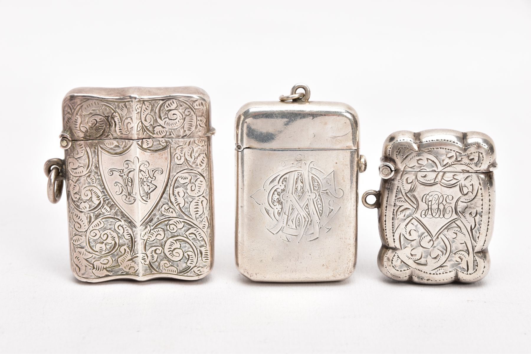 TWO LATE VICTORIAN SILVER VESTAS, AN EARLY 20TH CENTURY VESTA, AND A SMALL CERAMIC FIGURE, the first