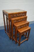 A CHINESE STYLE BAMBOO EFFECT CARVED HARDWOOD NEST OF FOUR TABLES, with glass inserts, the largest