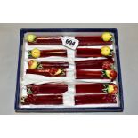 A BOXED SET OF FRENCH PORCELAIN KNIFE RESTS, fruit embossed to ends (Condition:- some chips and