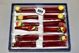 A BOXED SET OF FRENCH PORCELAIN KNIFE RESTS, fruit embossed to ends (Condition:- some chips and