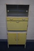 A DISTRESSED VINTAGE CREAM AND YELLOW KITCHEN CABINET, double glass sliding doors, fall front,