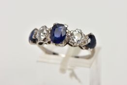 A WHITE METAL DIAMOND AND SAPPHIRE FIVE STONE RING, designed with three four claw set, oval cut blue