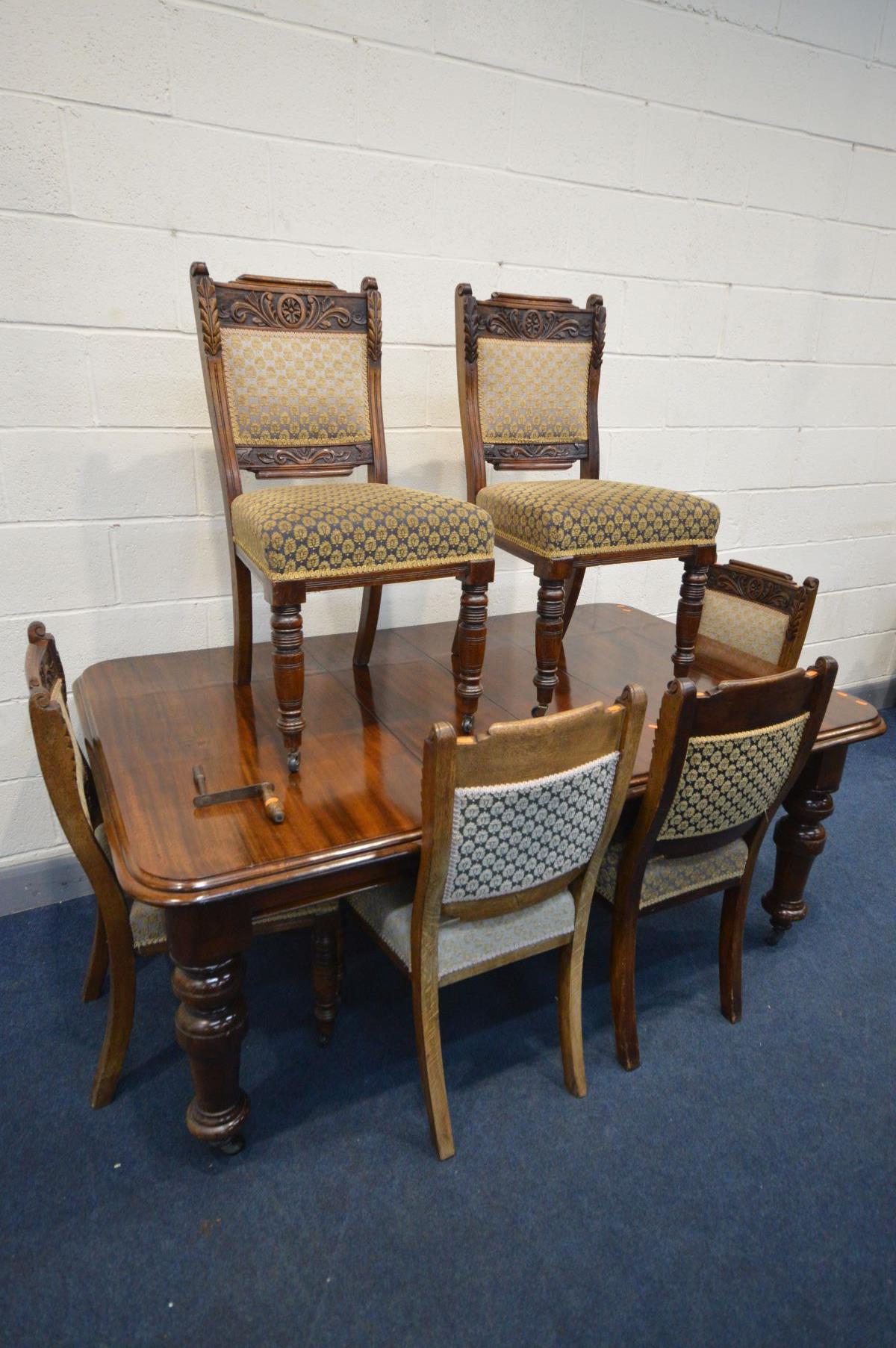 AN EDWARDIAN MAHOGANY WIND OUT DINING TABLE, with two additional leaves, on turned legs, extended