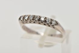 A WHITE METAL DIAMOND HALF ETERNITY RING, designed with a row of seven round brilliant cut diamonds,