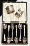 A CASED SET OF SIX SILVER TEASPOONS AND TWO NAPKIN RINGS, the teaspoons of a Hanoverian design, each