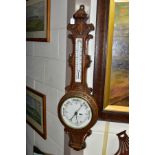 A LATE VICTORIAN OAK CASED ANEROID WHEEL BAROMETER, ceramic scale/dial for the thermometer and