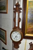 A LATE VICTORIAN OAK CASED ANEROID WHEEL BAROMETER, ceramic scale/dial for the thermometer and