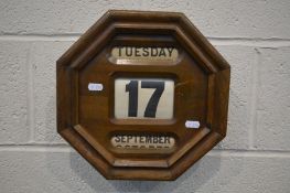 AN EARLY 20TH CENTURY OAK OCTAGONAL HANGING PERPETUAL CALENDAR, apertures for day, date and month,