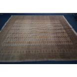 A WOOLLEN RUSSET TEKKE CARPET SQUARE, with a multi strap border, 368cm x 284cm (partially