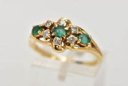 AN EMERALD AND DIAMOND RING, designed as a central oval emerald, surrounded by six round brilliant