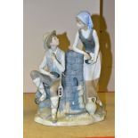 A NAO FIGURE GROUP OF A MAN AND WOMAN BESIDE A WATER PUMP, both eating from a bunch of grapes,