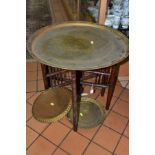 AN INDIAN BRASS TRAY TOP TABLE decorated with bands of script and floral motifs, diameter 59cm,