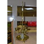 A BRASS AND GLASS THREE BRANCH CANDLE HOLDER, fitted with a central carrying handle to a three
