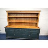 A GREEN PAINTED AND PINE DRESSER, the top with a fixed cornice and two fixed plate racks, the base