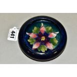 A MOORCROFT POTTERY SHALLOW BOWL WITH INVERTED RIM, decorated with a columbine on a dark blue