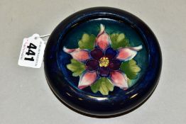 A MOORCROFT POTTERY SHALLOW BOWL WITH INVERTED RIM, decorated with a columbine on a dark blue