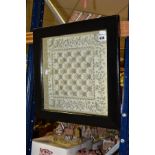 A VICTORIAN MIRRORED CHESS BOARD WITH BIRD AND FOLIATE SCROLL BORDER, MOUNTED IN A FRAME,