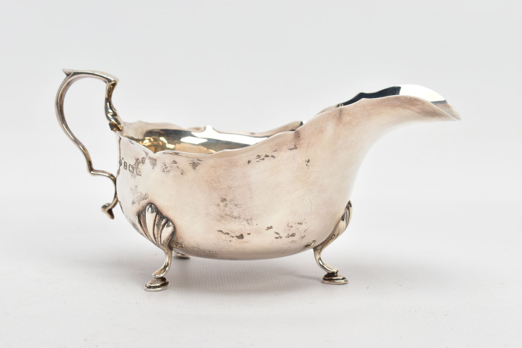 A GEORGE V SILVER GRAVY BOAT, plain polished design, wavy rim, scroll handle, fitted with three hoof - Image 3 of 6