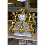 A LATE 19TH CENTURY GILT METAL AND ALABASTER MANTEL CLOCK, the white enamel dial flanked by two