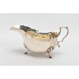 A GEORGE V SILVER GRAVY BOAT, plain polished design, wavy rim, scroll handle, fitted with three hoof