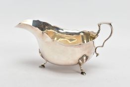 A GEORGE V SILVER GRAVY BOAT, plain polished design, wavy rim, scroll handle, fitted with three hoof