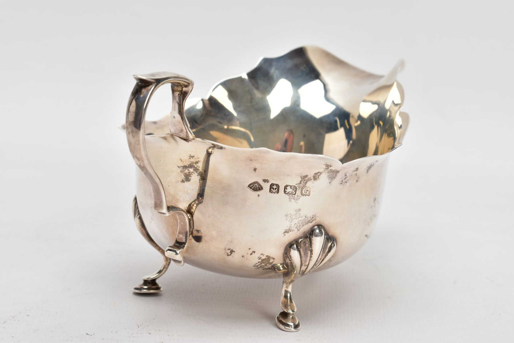 A GEORGE V SILVER GRAVY BOAT, plain polished design, wavy rim, scroll handle, fitted with three hoof - Image 4 of 6