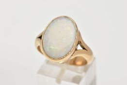 A HEAVY 9CT GOLD OPAL RING, designed with an oval cut opal cabochon, measuring approximately 12.