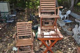 A STAINED PINE FOLDING GARDEN TABLE 76cm wide 60cm deep and a pair of hardwood folding chairs (3)