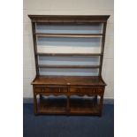 A GEORGIAN OAK DRESSER, the later triple plate rack top, over a base with two frieze drawers, five