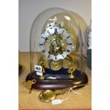 A LATE VICTORIAN BRASS SKELETON CLOCK UNDER A GLASS DOME, the clock with silvered dial with Roman