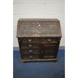 A LATE 19TH/EARLY 20TH CENTURY CARVED OAK BUREAU, with foliate detail and mask handles, width 92cm x