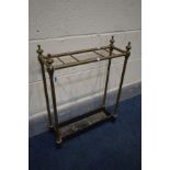 A 19TH CENTURY BRASS UMBRELLA STAND, finials to each support, on a black metal base (condition -