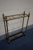 A 19TH CENTURY BRASS UMBRELLA STAND, finials to each support, on a black metal base (condition -